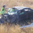 Una persona trata de auxiliar a los heridos tras el accidente de tráfico.
