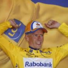 El ciclista danés del Rabobank levanta los brazos tras enfundarse el maillot amarillo