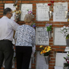 Dos personas cuidan de un nicho en un cementerio de Madrid.
