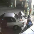 Imagen de la grabación de una cámara de seguridad en que se ve como unos ladrones intentan llevarse un gran botín de tabaco en un saco tan grande que no les cabe en el coche.