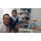 Ricardo Fernández posa con su hijo Marco en la habitación medicalizada que le mantenía con vida, en febrero de este año. FERNANDO OTERO