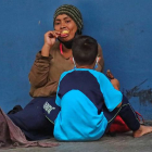 Una y un niño permanecen sentados en una calle en la que piden diner este miércoles en Tegucigalpa (Honduras). GUSTAVO AMADOR