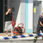 Un bombero ayuda a los residentes que desalojaban el edificio después una hora de encierro.