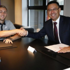 Gerard Deulofeu estrecha la mano de Josep Maria Bartomeu tras firmar su contrato.