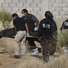 Varios forenses trasladan uno de los cuatro cadáveres hallados en las afueras de Ciudad Juárez.