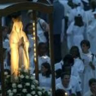 Una imagen de la virgen es llevada por los peregrinos durante una procesión nocturna en Lourdes