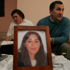 Los padres de la joven asesinada, junto a su retrato.