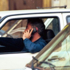Un hombre habla por teléfono móvil al volante.