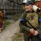 Una mujer pasa ante un miembro de la Guardia Nacional ucraniana. OLEG PETRASYUK
