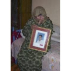 Zeinab Wali, madre de El Egipcio, posa con un retrato de éste en el interior de su casa en  Aziziya