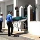 Empleados de una funeraria retiran el cuerpo de la mujer asesinada