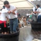 La imagen muestra a dos parejas mientras competían en el concurso de pisada de uva ayer en Cacabelos