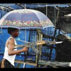 Una de las imágenes premiadas de Nick Bothma que muestra a un rebelde liberiano ante una casa acribillada a balazos. Está tomada en Monrovia.