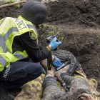 Imagen de un soldado ucraniano fotografiando el cadáver de un civil en Jarkov. VASILIY ZHLOBSKY