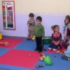 Los niños y la monitora juegan en las dependencias de la sala