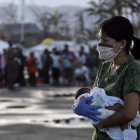 Una enfermera lleva en brazos a un bebé de siete días para evacuarlo.