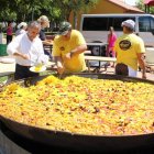 El alcalde de la localidad ayuda a servir la gran paellada para los mayores de la ciudad.