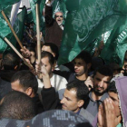 Un grupo de palestinos ondea sus banderas en en protesta por los ataques del ejército israelí.