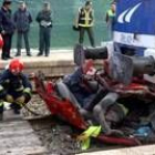 Los bomberos de Albacete examinan los restos del vehículo destrozado por el tren ayer en Hellín