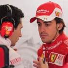Alonso escucha a un mecánico de Ferrari tras la segunda sesión de entrenamientos libres.