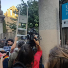 Los mossos se han ido y varias personas entran la escuela Collaso i Gil con la ayuda de una escalera entre aplausos
