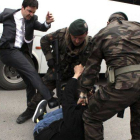 Un hombre identificado como Yusuf Yerkel, asesor de Recep Tayyip Erdogan, da un puntapié a un manifestante en Soma durante la visita del primer ministro a la localidad, el miércoles.