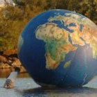 Un niño sostiene un gigantesco globo terráqueo instalado en el Foro Social de Porto Alegre