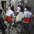 Médicos palestinos evacúan un cadáver en el barrio de Shayahía, este domingo.