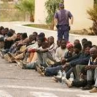 Un guardia civil vigila a una parte de los inmigratnes detenidos ayer tras el asalto a la valla
