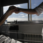 Una enfermera estrecha la mano de una paciente en cuidados paliativos en León.