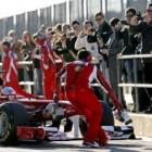 Fernando Alonso y su bólido, rodeados de aficionados en el «pit lane» de Cheste.