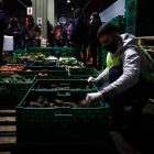Un trabajador coloca jaulas de frutas y verduras en un mercado central para su distribución. JUAN IGNACIO RONCORONI