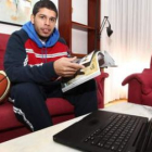 Manny Quezada ojea una revista en su casa, después del entrenamiento, junto al ordenador y el balón.