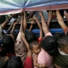 Decenas de personas se amontonan junto a los camiones que reparten ayuda en Sri Lanka