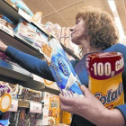 Una mujer compra Cola Cao  en un supermercado.