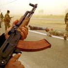 Soldados gubernamentales controlan a insurgentes en una carretera