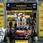 Kris Meeke (derecha) y su copiloto Paul Nagle celebran el triunfo en el Rally de Cataluña sobre el capó de su Citroën.