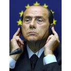 Berlusconi escucha por el traductor las críticas de los parlamentarios