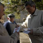 Martínez entrega uno de los trípticos a dos hombres en San Marcelo