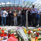Varias personas rezan en el memorial de velas y flores, colocada frente al centro comercial Olympia, en Munich, este domingo.