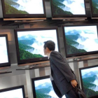 Una persona observa la calidad de un 'video-wall' formado por televisores de alta definición (HD).