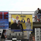 Ciudadanos caminan frente a varios carteles electorales en Quito.