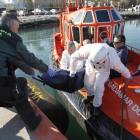 Agentes de la Guardia Civil y de Salvamento Maritimo trasladan el cadáver de uno de los inmigrantes fallecidos en aguas del Estrecho.