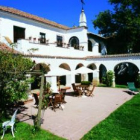 El encantador jardín, una habitación con camas con dosel y un salón de La Posada del Marqués.