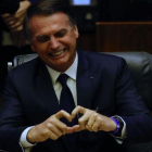 El presidente brasileño, Jair Bolsonaro, muestra un corazón con sus dedos durante su toma de posesión en el Parlamento.