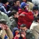 Los aficionados se protegen del humo durante los incidentes en el campo del Catania