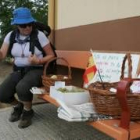 Una peregrina mira la fruta en el banco junto a la casa de Agapito