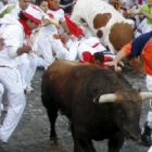 Un toro de la ganadería de El Ventorrillo pasa junto a varios mozos.
