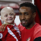 Jermain Defoe, delantero del Sunderland, sostiene en brazos a Bradley Lowery.