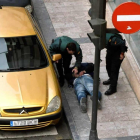 Dos agentes de la Guardia Civil junto al atracador detenido que permanece esposado. EFE